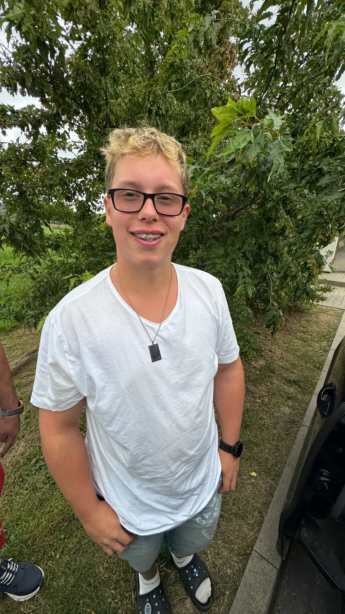Luca, ein 17-jähriger Jugendlicher mit Brille und blondem Haar, lächelt in die Kamera